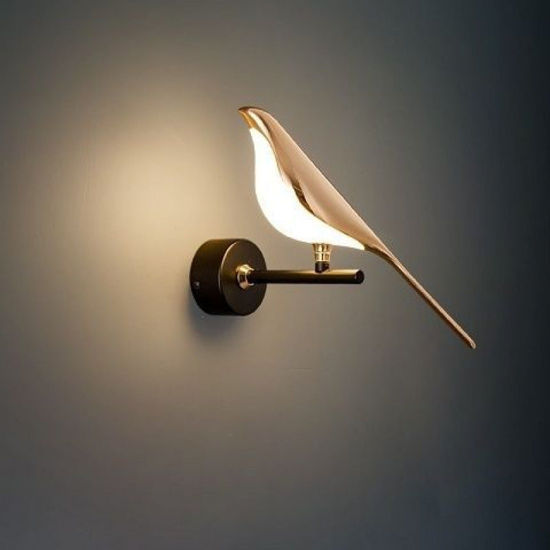 Perched magpie wall lamp holding a warm light