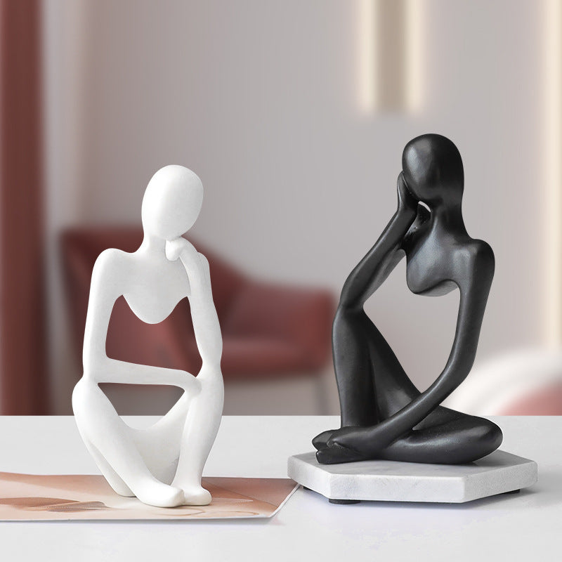 Small abstract meditating figure cast in resin, 13cm tall