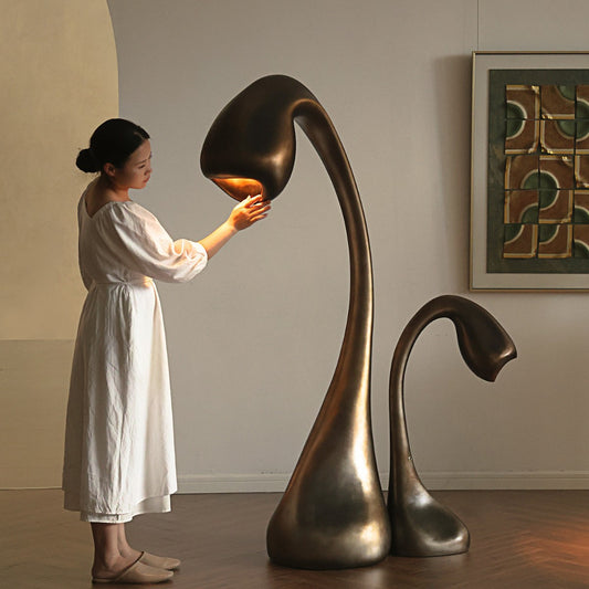 Sculptural floor lamp shaped like an opening bud, in fibreglass